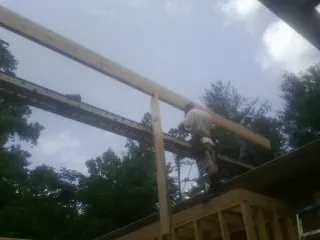Carpenter setting a ridge beam over a new addition frame — Ice Dam Removal by Roofing Brothers in Maytown