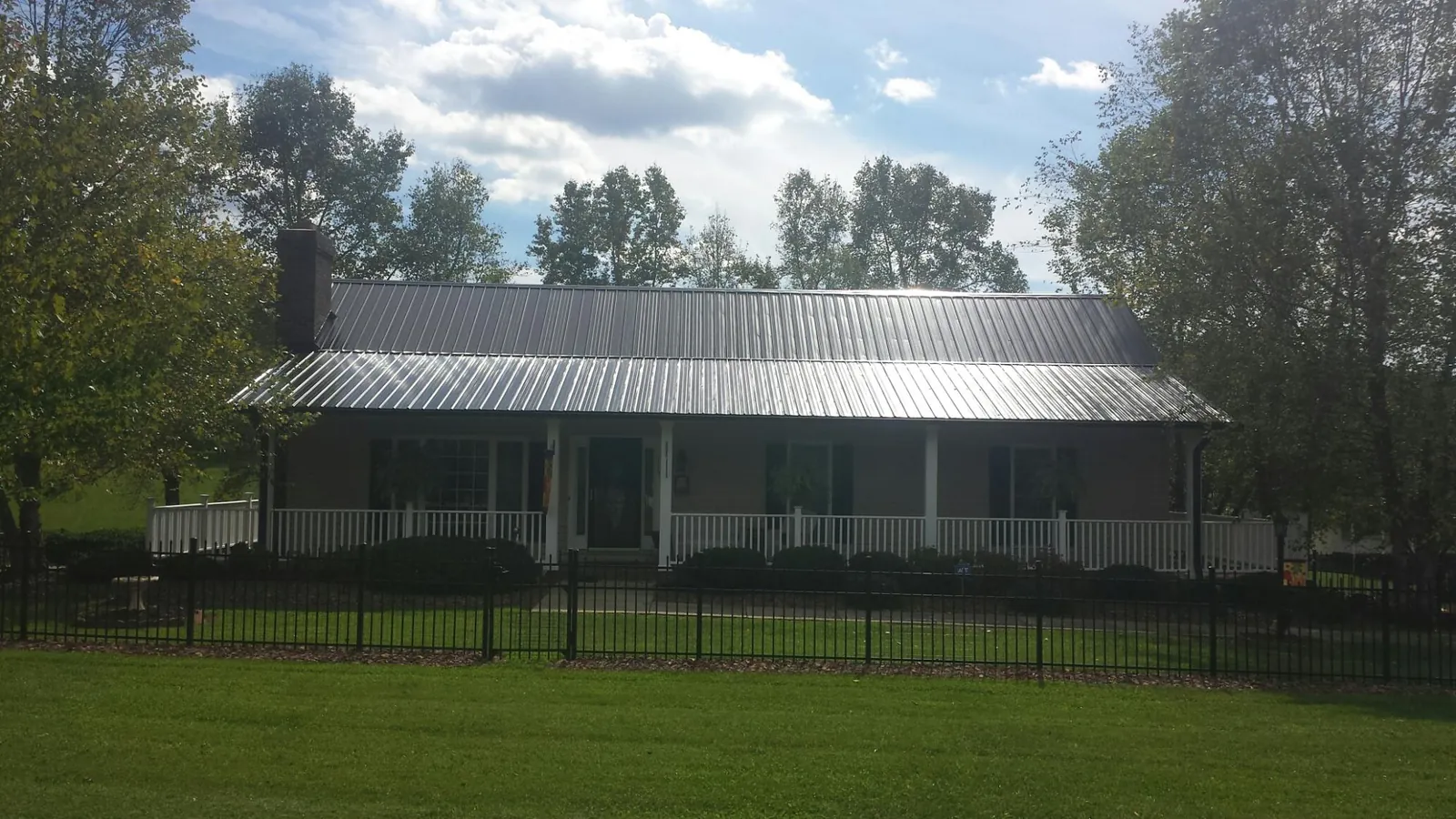Gray metal roof on a brick ranch with a full width front porch — Gutter Guard Installation work by our crew in Maytown
