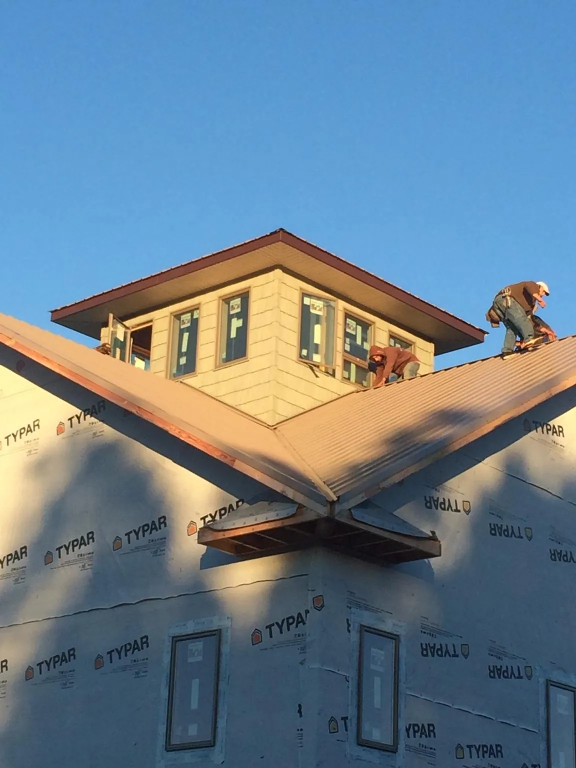 Roofers working around a rooftop cupola on a new metal roof at sunset — Roof Waterproofing in Maytown by Roofing Brothers